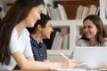 Different ethnicity students girls sitting at desk studying together Royalty Free Stock Photo
