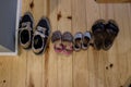 Different family shoes, bigger and smaller on a hardwood interior house