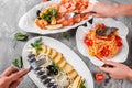 Different food with Seafood platter with smoked mackerel slice, fried potatoes, salmon slice, shrimp and vegetable salad on table Royalty Free Stock Photo