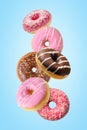 Different fresh donuts on blue background. Minimal food concept
