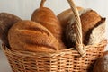 Different freshly baked bread loafs in wicker basket on table, closeup Royalty Free Stock Photo