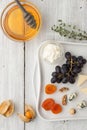 Different fruit and cheese with honey and sprig of thyme