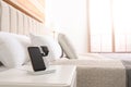 Different gadgets charging on wireless pad in bedroom Royalty Free Stock Photo