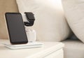 Different gadgets charging on wireless pad in bedroom. Space for text Royalty Free Stock Photo