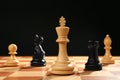 Different game pieces on chessboard against dark background
