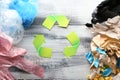 Different garbage with symbol of recycling on light wooden background. Ecology concept Royalty Free Stock Photo