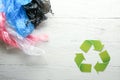 Different garbage with symbol of recycling on white wooden background. Ecology concept Royalty Free Stock Photo