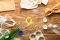 Different garbage with symbol of recycling on wooden background. Ecology concept Royalty Free Stock Photo