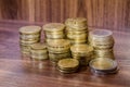 Different golden euro coins on wooden table