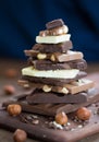 The different grades of chocolate put by the hill on a wooden board, with a filbert can on a rust metal surface. Nuts and sweets. Royalty Free Stock Photo