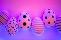 Different graphic hand-painted eggs in Proton Purple neon light. Royalty Free Stock Photo