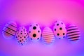 Different graphic hand-painted eggs in Proton Purple neon light. Royalty Free Stock Photo