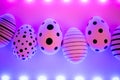 Different graphic hand-painted eggs in Proton Purple neon light. Royalty Free Stock Photo