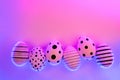 Different graphic hand-painted eggs in Proton Purple neon light. Royalty Free Stock Photo