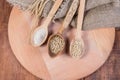 Different groats, whole barley grains in wooden spoons, top view