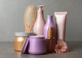 Different hair products, flower and brush on grey table Royalty Free Stock Photo