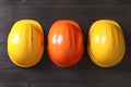 Different hard hats on wooden background, flat lay