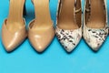 Different high heel shoes on blue background. Royalty Free Stock Photo