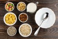 Ingredients for muesli dried fruits, corn flakes, oatmeal, sunflower seeds, banana chips, yogurt and bowl, spoon on table. Top Royalty Free Stock Photo