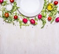 Different ingredients for salad, radish, cherry tomatoes and seasonings, the plates laid out around border ,place for text top