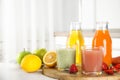 Different juices and fresh fruits on white table