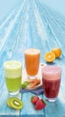 Different Juices in One Group Picture Includes Kiwi Juice, Strawberry Juice, Orange Juice with Carrots Juice. On Blue Wood Royalty Free Stock Photo
