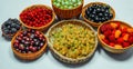 Different kind of baskets with fruits on white background. Red, black and white currant, green and red gooseberry, blackberry Royalty Free Stock Photo