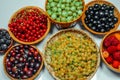 Different kind of baskets with fruits on white background. Red, black and white currant, green and red gooseberry, blackberry Royalty Free Stock Photo