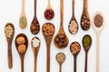 Different kind of beans and lentils in wooden spoon on white woo