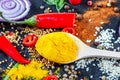 Different kind of spices and herbs and chili on a black stone background Royalty Free Stock Photo