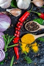 Different kind of spices and herbs, chili, garlic and onion on a black stone background. The view from the top. Flatley Royalty Free Stock Photo