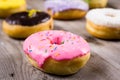 Different kinde of round donuts on wooden table. Closeup Royalty Free Stock Photo