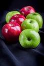 Green and red of apples on black fabric background Royalty Free Stock Photo