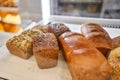 Different kinds of bread on the counter in the bakery shop. Fresh bread counter. Modern bakery with different kinds of