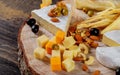 Different kinds of cheese, olives and assorted nuts wood background Royalty Free Stock Photo