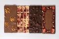 Different kinds fof chocolate bars laying down in a row on wooden white background.