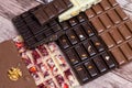 Different kinds fof chocolate bars on vintage wooden background.