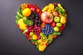 Different kinds of fruits and vegetables laid out on dark background in shape of heart Royalty Free Stock Photo