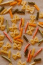 Different kinds of Italian pasta on rustic background. Multicolored pasta flavors.