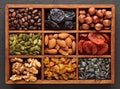 Different kinds of nuts, dried fruits  in wooden box on black slate background. Top view. Healthy food. Vegetarian nutrition Royalty Free Stock Photo