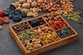 Different kinds of nuts, dried fruits  in wooden box on black slate background. Top view. Healthy food. Vegetarian nutrition Royalty Free Stock Photo