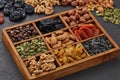 Different kinds of nuts, dried fruits  in wooden box on black slate background. Top view. Healthy food. Vegetarian nutrition Royalty Free Stock Photo