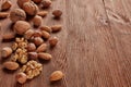 Various types of nuts. Whole nuts and kernels on brown textured wooden background. Top view with copy space. Healthy food Royalty Free Stock Photo