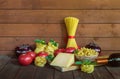 Different kinds of raw pasta, fresh vegetables, piece of parmesan cheese  and bottle of red wine. Selective focus. Royalty Free Stock Photo