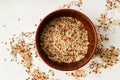 Different kinds on rice mixed together in a bowl on white background, top view