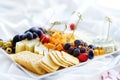 Different kinds of wine snacks: cheeses, crackers, fruits and olives on white table Royalty Free Stock Photo