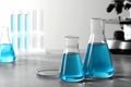 Different laboratory glassware with light blue liquid on table. Space for text Royalty Free Stock Photo