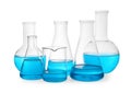 Different laboratory glassware with light blue liquid on white background Royalty Free Stock Photo