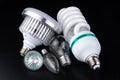 Different light bulbs and fluorescent lights on a wooden table. New types of lighting Royalty Free Stock Photo