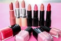 Different lipsticks and nail polishes on color background. Professional cosmetic